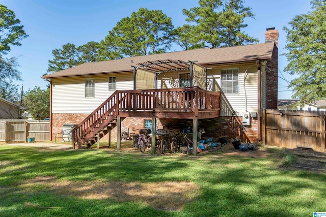 back of property featuring a wooden deck and a lawn