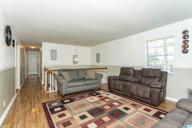 living room featuring wood-type flooring and a textured ceiling