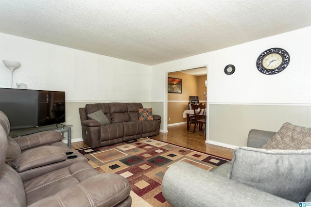 living room featuring dark wood-type flooring and a textured ceiling