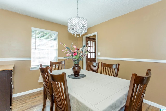 dining area with hardwood / wood-style floors and a chandelier