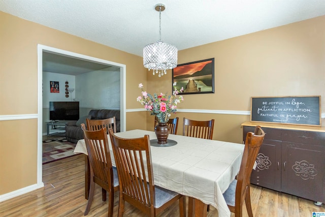 dining area with an inviting chandelier and light wood-type flooring