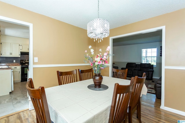 dining room with a chandelier, hardwood / wood-style flooring, and a textured ceiling