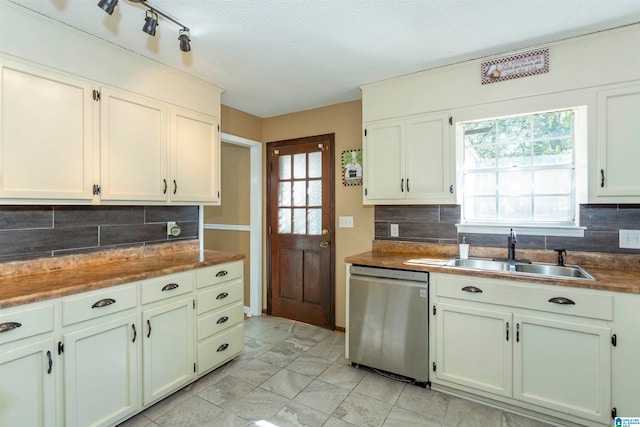 kitchen featuring stainless steel dishwasher, backsplash, sink, and a healthy amount of sunlight