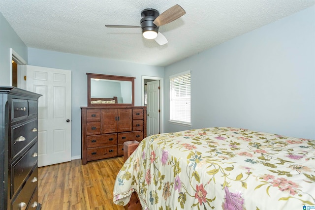 bedroom featuring a textured ceiling, light hardwood / wood-style floors, and ceiling fan