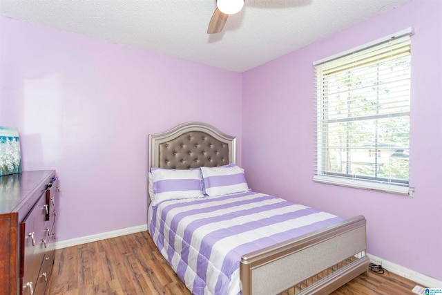 bedroom featuring hardwood / wood-style floors, a textured ceiling, and ceiling fan