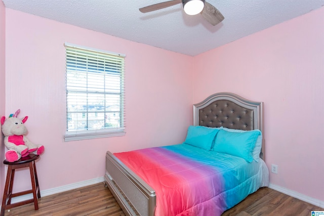 bedroom featuring a textured ceiling, dark wood-type flooring, and ceiling fan