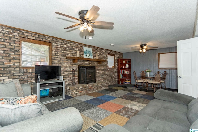 carpeted living room featuring brick wall, a textured ceiling, a fireplace, and ceiling fan