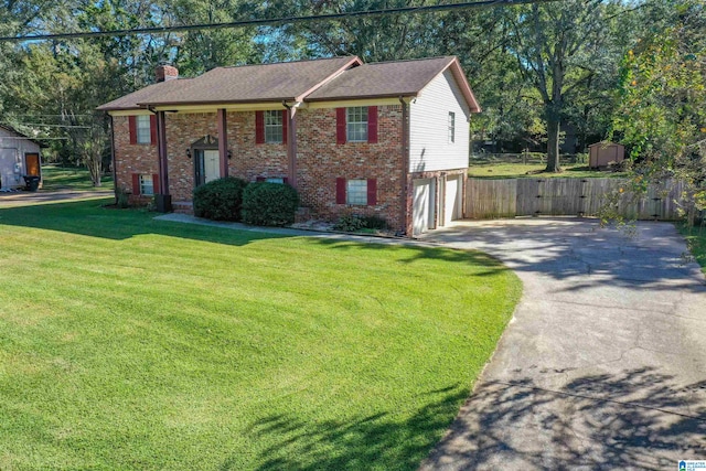 raised ranch with a shed, a front lawn, and a garage