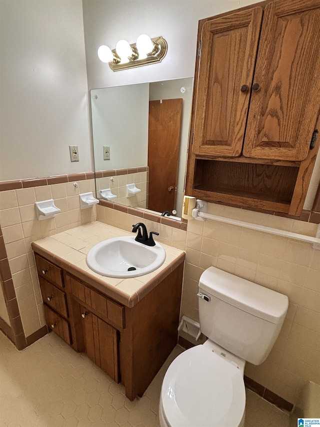 bathroom featuring tile patterned floors, vanity, and tile walls