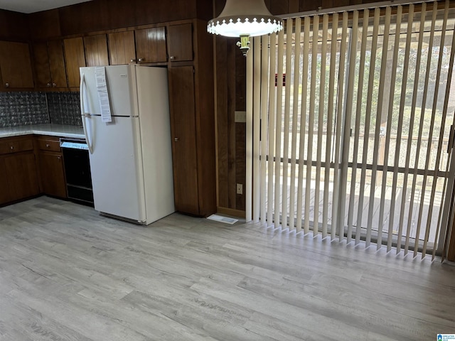 kitchen featuring backsplash, dishwasher, white fridge, and light wood-type flooring