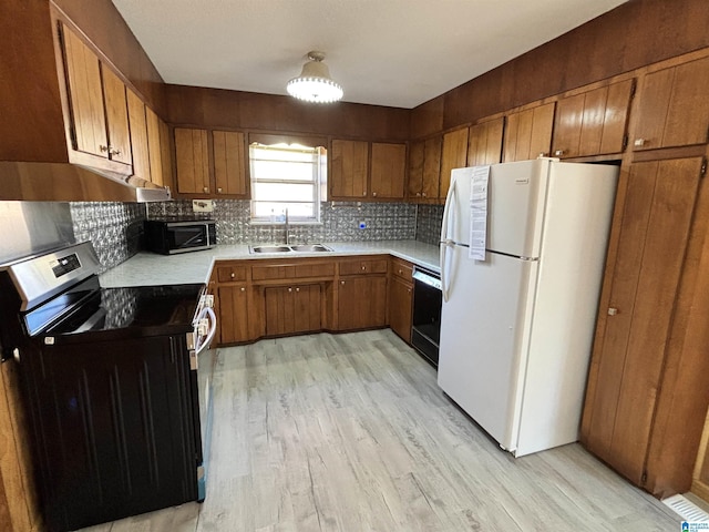 kitchen featuring range with electric cooktop, sink, tasteful backsplash, white refrigerator, and light hardwood / wood-style floors