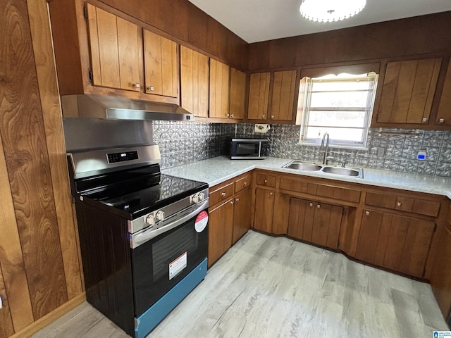 kitchen featuring light wood-type flooring, sink, appliances with stainless steel finishes, and tasteful backsplash