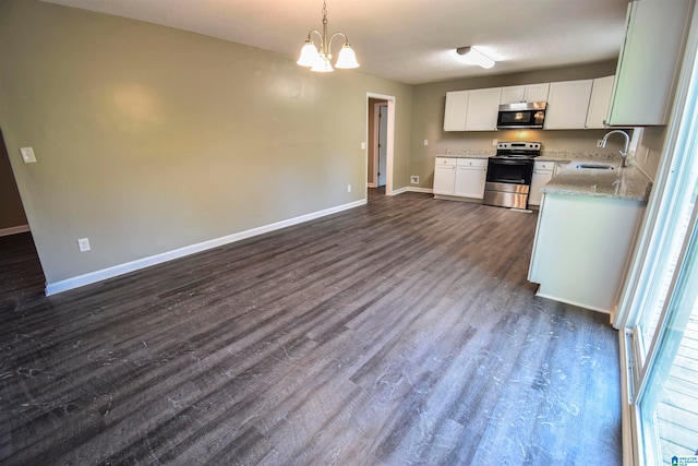 kitchen featuring hanging light fixtures, dark hardwood / wood-style flooring, white cabinetry, sink, and stainless steel appliances