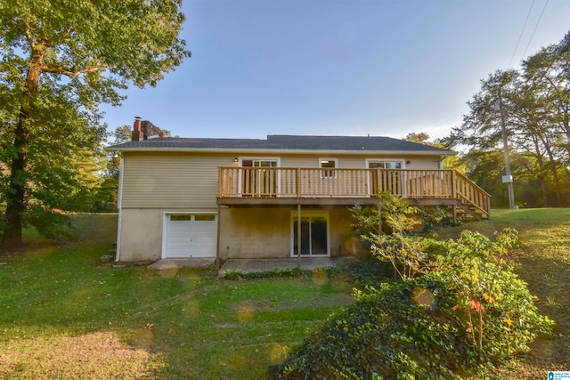 rear view of house featuring a wooden deck, a garage, and a lawn