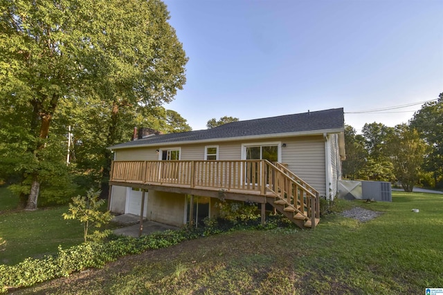 back of house featuring a wooden deck, a garage, and a lawn