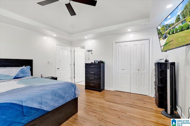 bedroom with light hardwood / wood-style flooring, ornamental molding, a closet, and ceiling fan