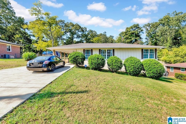 view of front facade with a front lawn, central air condition unit, and a carport