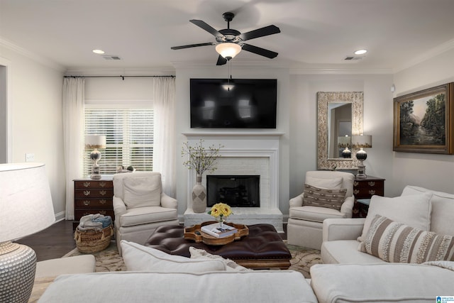 living room featuring ceiling fan, crown molding, a brick fireplace, and hardwood / wood-style floors