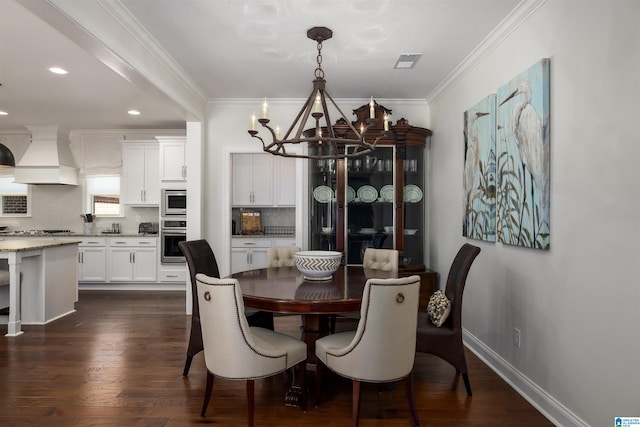 dining space with dark wood-type flooring, crown molding, and an inviting chandelier