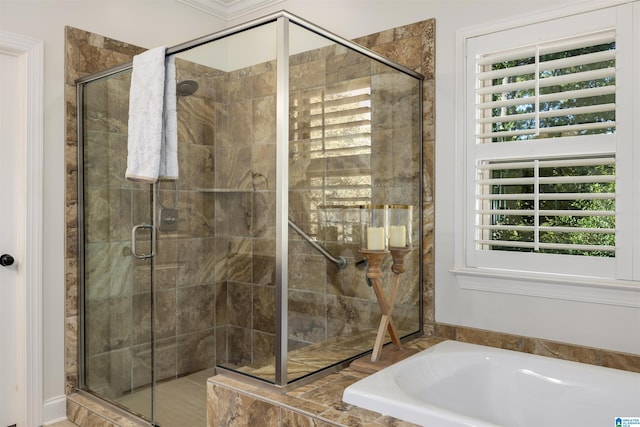 bathroom with a healthy amount of sunlight and separate shower and tub