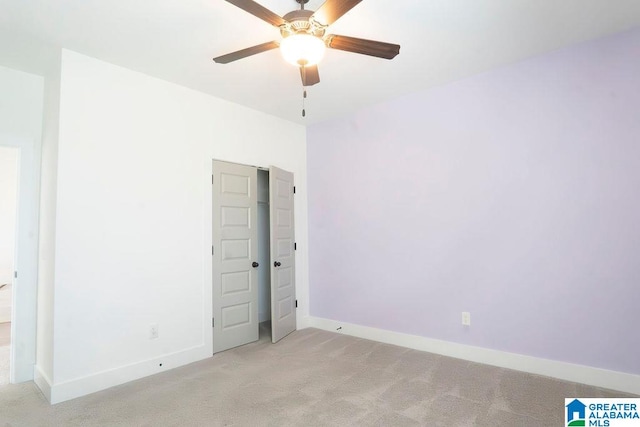 spare room with ceiling fan and light colored carpet