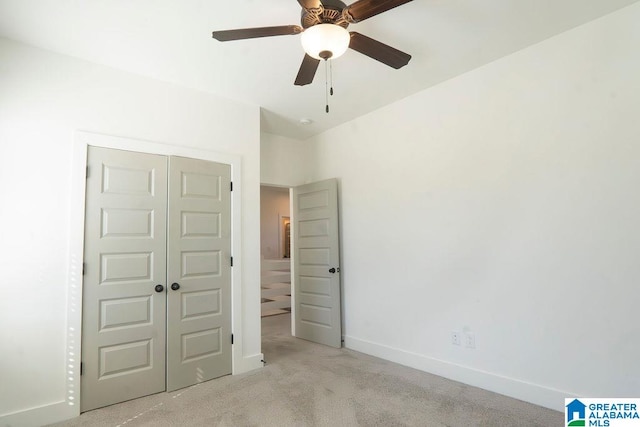 unfurnished bedroom featuring a closet, ceiling fan, and light colored carpet