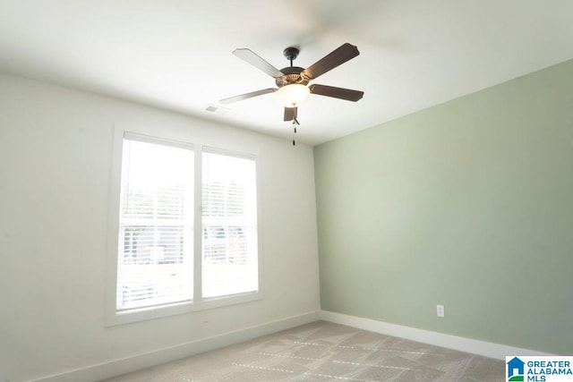 empty room with light carpet, ceiling fan, and a wealth of natural light