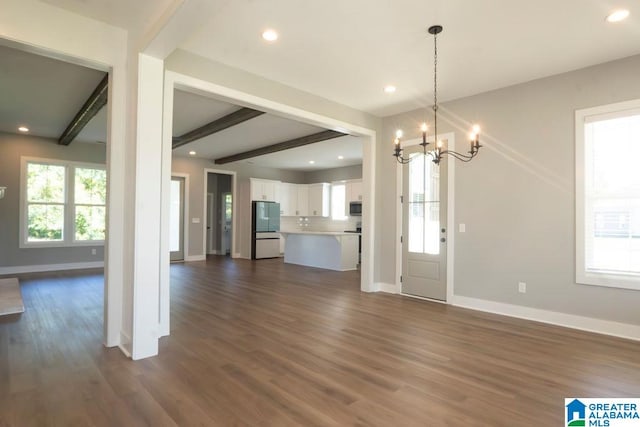 unfurnished living room with beamed ceiling, dark hardwood / wood-style flooring, and an inviting chandelier