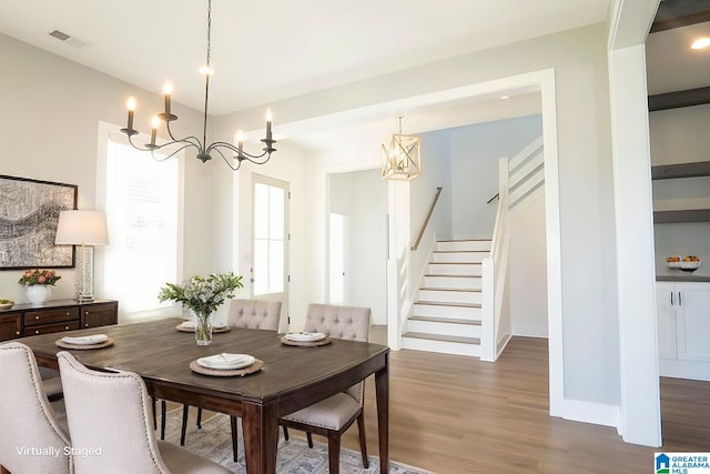 dining area featuring hardwood / wood-style floors and a chandelier