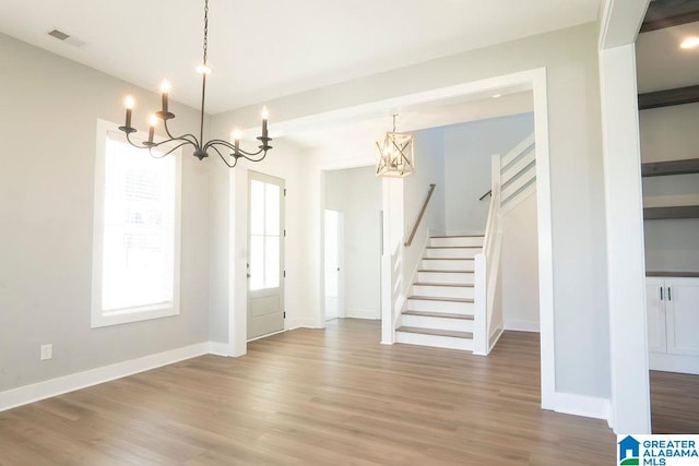 unfurnished dining area with hardwood / wood-style flooring and a chandelier