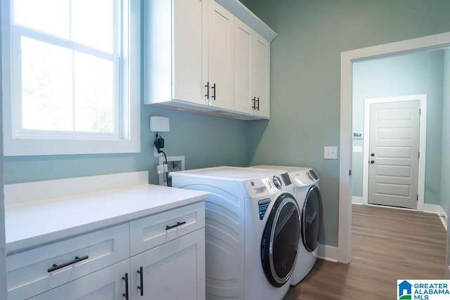 washroom with cabinets, washer and dryer, and hardwood / wood-style floors