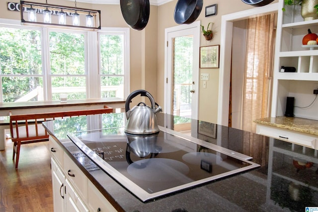 kitchen featuring white cabinetry, a wealth of natural light, black electric cooktop, and dark hardwood / wood-style flooring