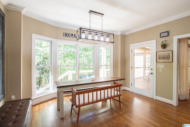 dining space with hardwood / wood-style flooring and ornamental molding