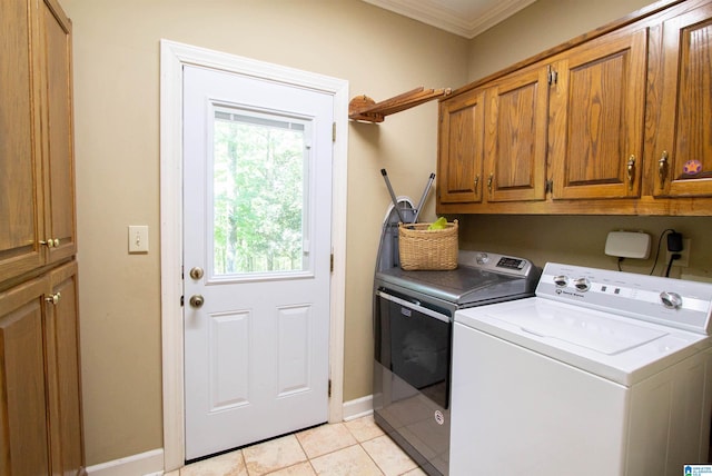 laundry room with light tile patterned floors, crown molding, cabinets, and washing machine and clothes dryer