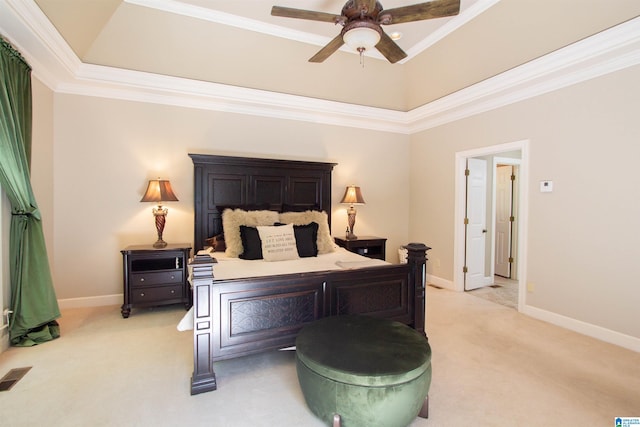 carpeted bedroom with crown molding, a tray ceiling, and ceiling fan