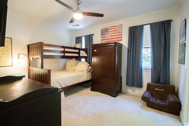 carpeted bedroom featuring crown molding and ceiling fan