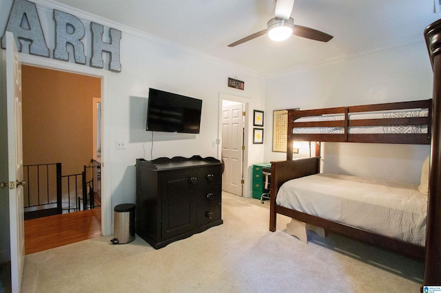 bedroom with ornamental molding, light carpet, and ceiling fan