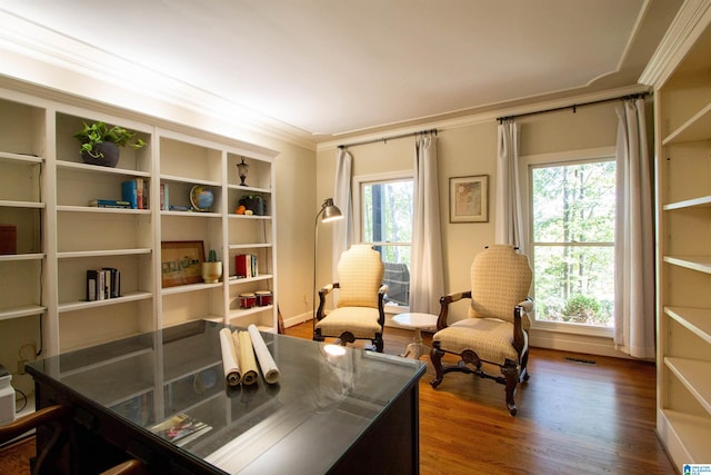 sitting room with ornamental molding, a wealth of natural light, and dark hardwood / wood-style flooring