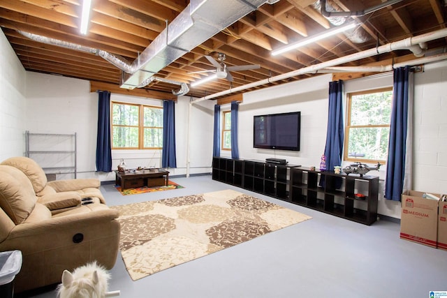 living room featuring a healthy amount of sunlight, concrete flooring, and ceiling fan