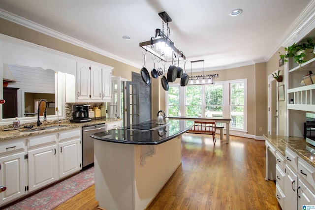 kitchen with sink, a center island, white cabinetry, light hardwood / wood-style floors, and stainless steel dishwasher