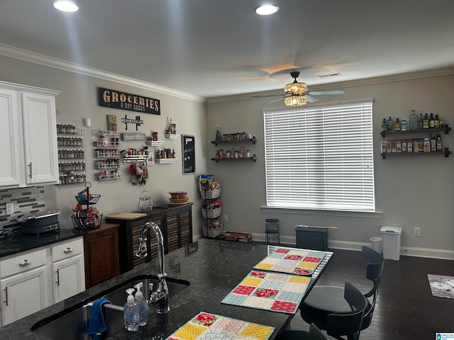 kitchen featuring ornamental molding, dark wood-type flooring, white cabinets, and a healthy amount of sunlight