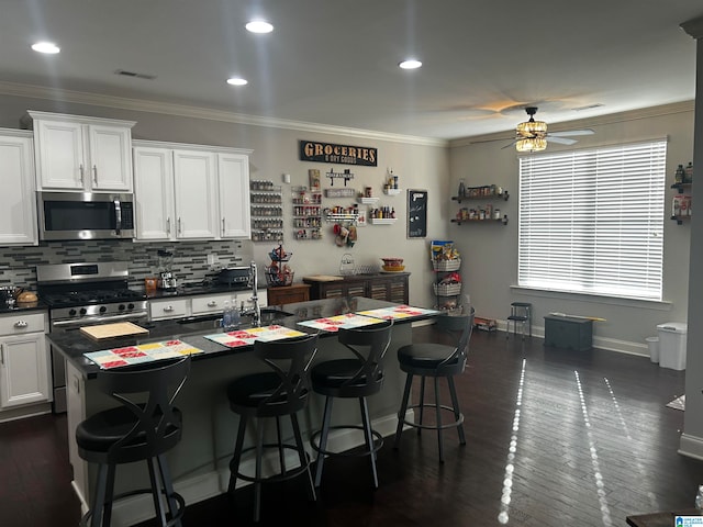 kitchen with ornamental molding, sink, white cabinetry, and stainless steel appliances