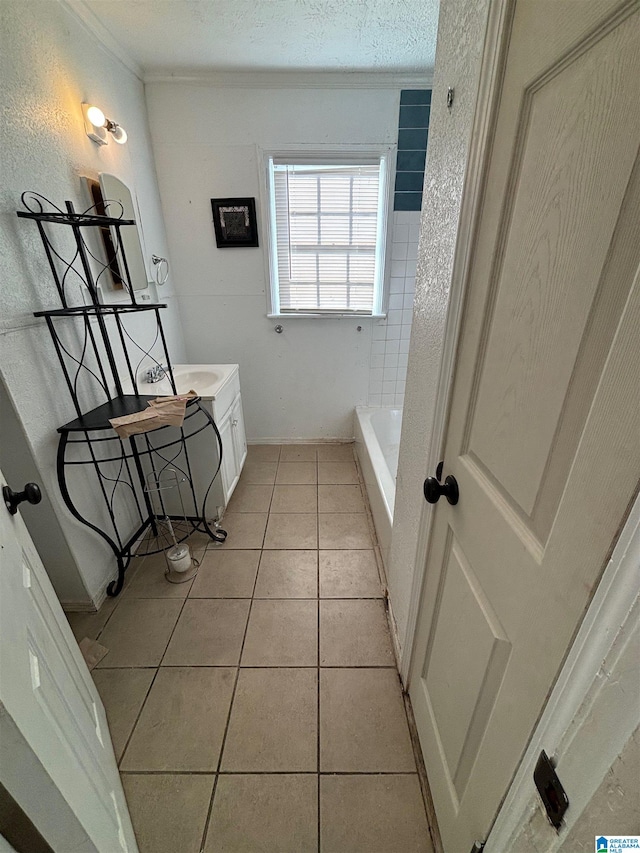 bathroom with vanity, a bathtub, a textured ceiling, and tile patterned flooring