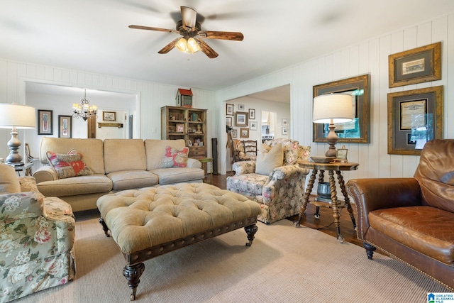 living room with wood-type flooring and ceiling fan with notable chandelier