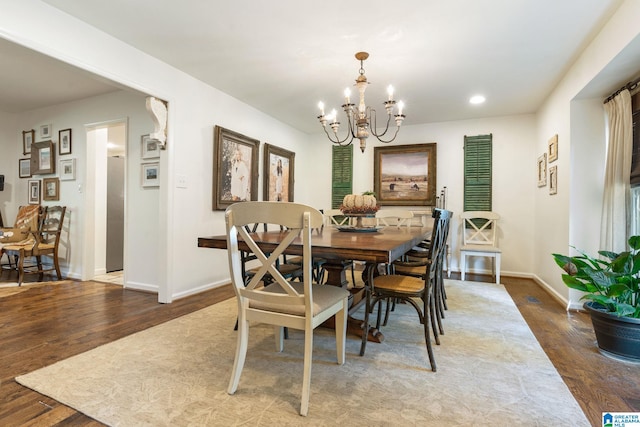 dining space featuring wood-type flooring and a chandelier