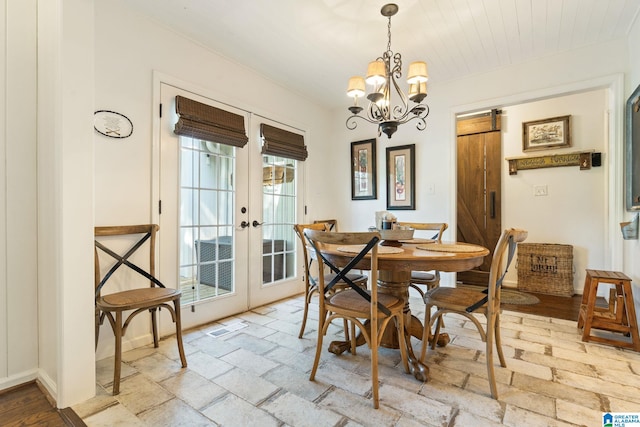 dining area with a barn door, a notable chandelier, and french doors