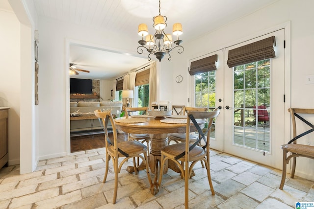 dining space featuring french doors and ceiling fan with notable chandelier