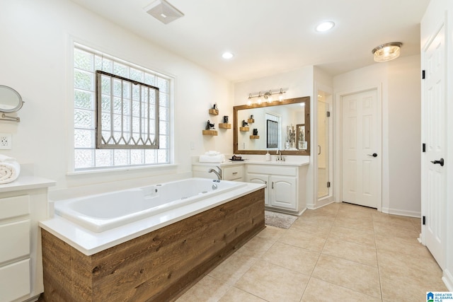 bathroom with a bathtub, vanity, a healthy amount of sunlight, and tile patterned floors