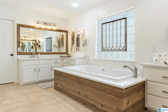 bathroom featuring tile patterned flooring, a bathtub, vanity, and a healthy amount of sunlight