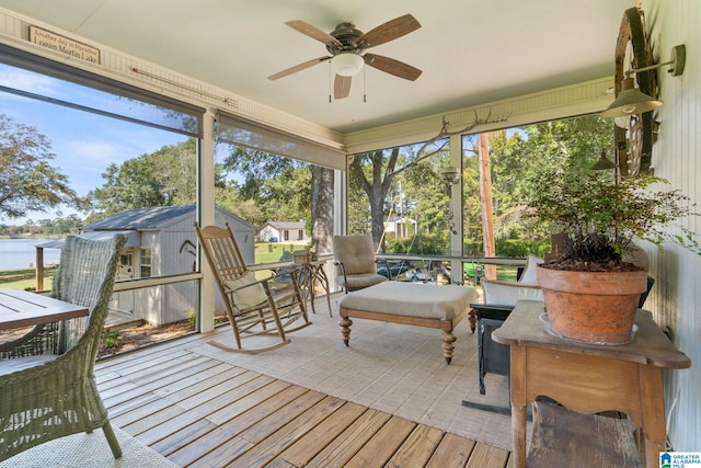 sunroom / solarium featuring ceiling fan, a healthy amount of sunlight, and a water view